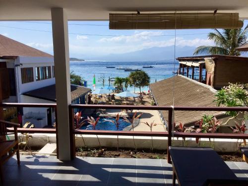 a view of a swimming pool and the ocean from a balcony at Dream Divers Resort in Gili Trawangan