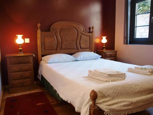 a bedroom with a bed with two lamps and towels on it at 107 Rosario, Guesthouse in Porto