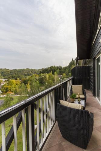 a balcony with a wicker chair and a couch at Duplex Penthouse Aparthotel Rosa in Podčetrtek