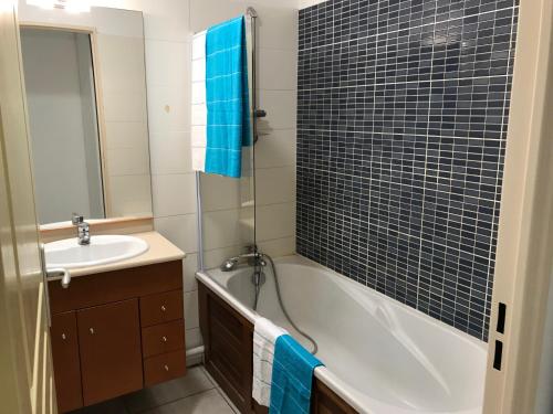サンジルレバンにあるMeublé Homard avec jacuzzi et vue merのバスタブと洗面台のあるバスルーム