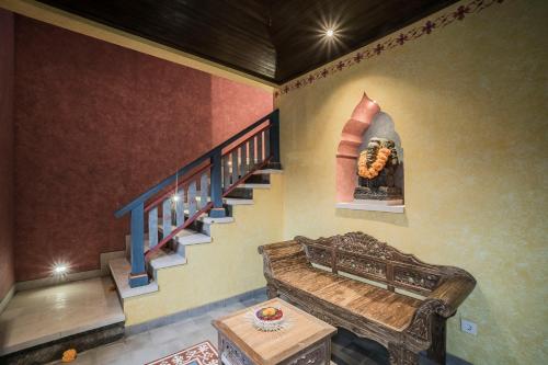 a room with a staircase with a bench and a painting at Villa Tanah Carik by Mahaputra in Tegalalang