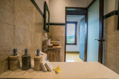 a bathroom with a sink and two faucets at Villa Tanah Carik by Mahaputra in Tegalalang