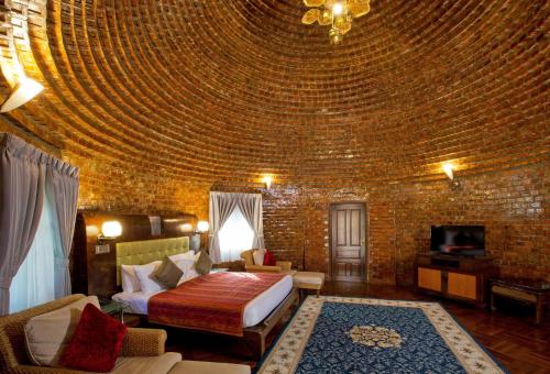 a bedroom with a bed and a brick wall at Ammata Lanta Resort in Lat Krabang
