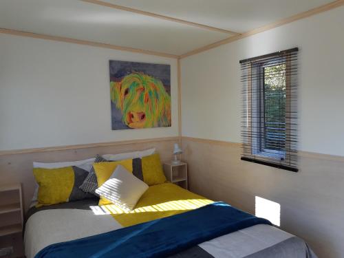 a bedroom with a bed with a painting of a horse at Jackson's Retreat Alpine Holiday Park in Jacksons