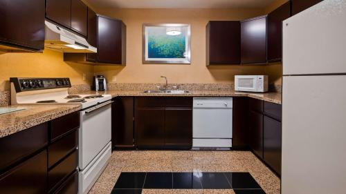 a kitchen with brown cabinets and white appliances at Best Western Gaylord in Gaylord