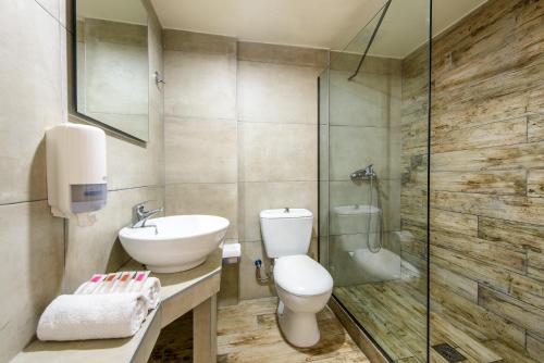 La salle de bains est pourvue de toilettes, d'un lavabo et d'une douche. dans l'établissement Eurohotel Katrin Hotel & Bungalows, à Stalida