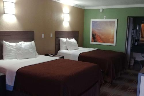 A bed or beds in a room at Days Inn by Wyndham Houston East