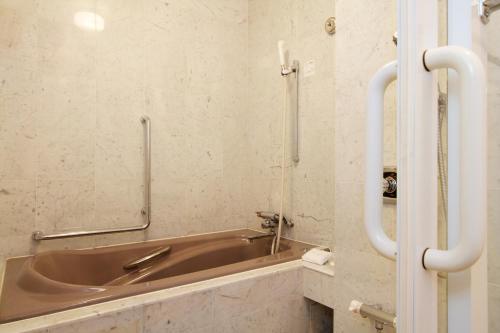 a bathroom with a copper sink in a room at Hotel Agora Osaka Moriguchi in Osaka