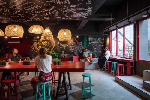 a restaurant with colorful stools and people sitting at tables at Kitez Hotel & Bunkz in Kuala Lumpur