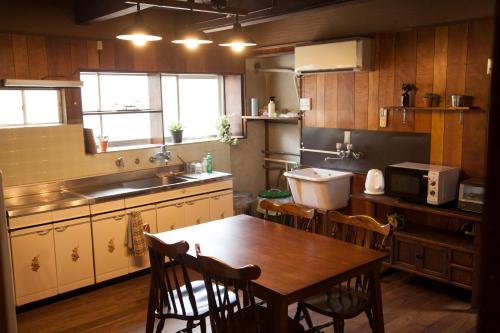 a kitchen with a table and chairs and a sink at Guest House tokonoma in Shimo-yuge