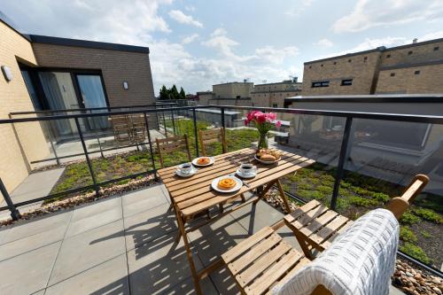 a balcony with a wooden table and chairs on a roof at Boardinghouse St.Pauli in Hamburg