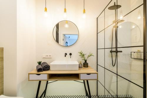 W łazience znajduje się umywalka i lustro. w obiekcie Marina View Apartment z prywatnym parkingiem w hali garażowej w Iławie