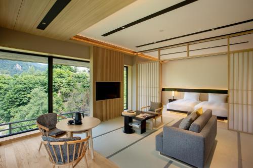 a hotel room with a king bed and a living room at Chalet Ivy Jozankei in Jozankei