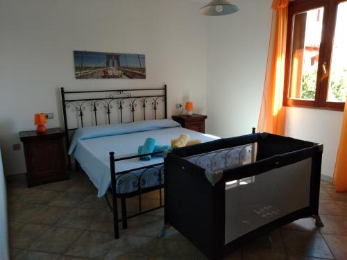 een slaapkamer met een bed en een babybedje bij Sa Pira in Budoni