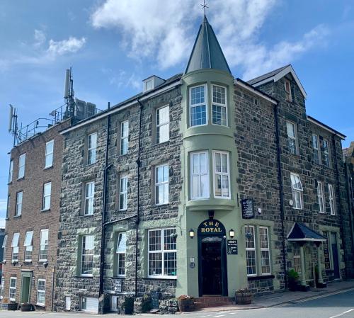a large brick building with a turret on a street at The Royal in Barmouth