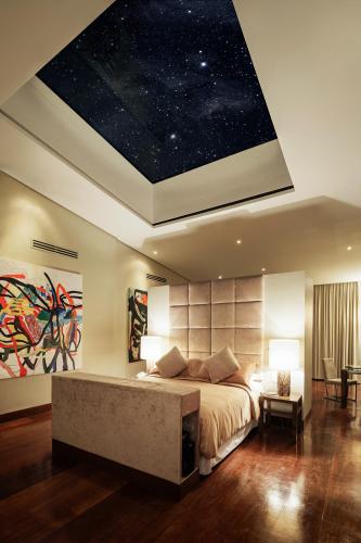 a bedroom with a large bed with a star ceiling at Under the Stars Luxury Apartment in Boracay