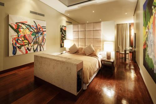 a bedroom with a bed and a painting on the wall at Under the Stars Luxury Apartment in Boracay