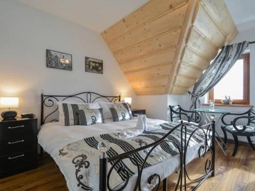 ゾンプにあるHawrańの木製の天井のベッドルーム1室(黒いベッド1台付)
