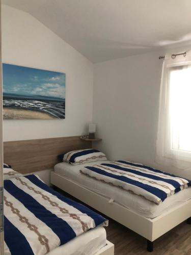 2 Betten in einem Zimmer mit Fenster in der Unterkunft Ideal Holiday Apartment 2 in Tribunj