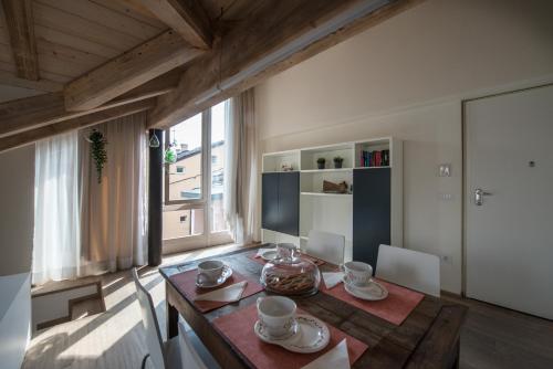 a dining room with a wooden table and a large window at Il Riposo del Gladiatore in Aosta