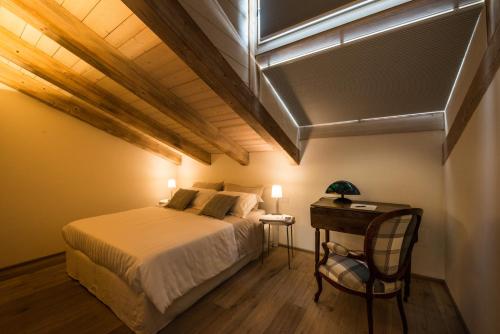 1 dormitorio con 1 cama y 1 mesa con silla en Il Riposo del Gladiatore, en Aosta