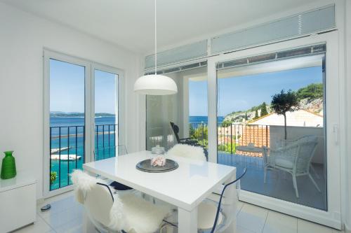 a white dining room with a view of the ocean at Blue Bay Residence in Hvar