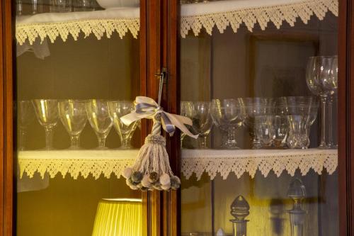 a shelf filled with wine glasses and a lamp at Villa Mocarello in Poggibonsi
