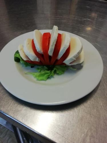 a white plate with a dessert on a table at Hotel Flora in Cesenatico