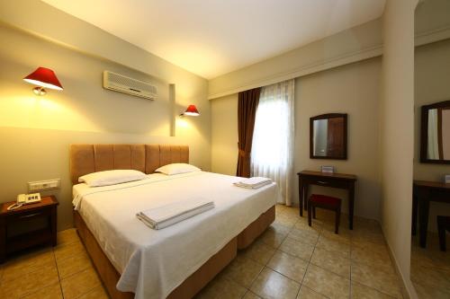 a bedroom with a bed with two towels on it at Mr. Dim Exclusive Apart Hotel in Göcek