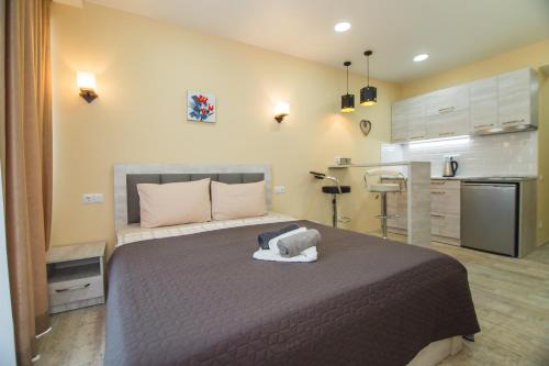 a bedroom with a large bed and a kitchen at Real Beach Tower in Batumi