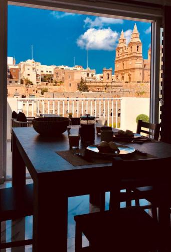 a table with a view of a city from a window at Brand new Mellieha sea view apt with parking in Mellieħa
