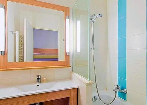 een badkamer met een douche, een wastafel en een spiegel bij Studio 4 personnes, climatisé, rez de jardin in Saint-Raphaël