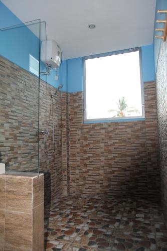 a bathroom with a shower and a window at Karma Amed Guesthouse in Amed