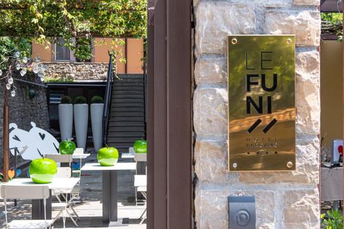 a sign on the side of a building with tables and chairs at Le Funi Hotel in Bergamo