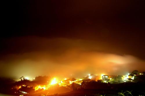 a town on a hill engulfed in fire at night at Alishan B&B YunMinGi in Fenchihu