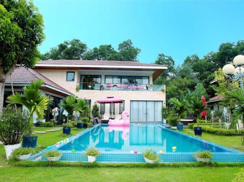 uma casa com piscina em frente a uma casa em Flamingo Happy Villa Owner em Ngọc Quang