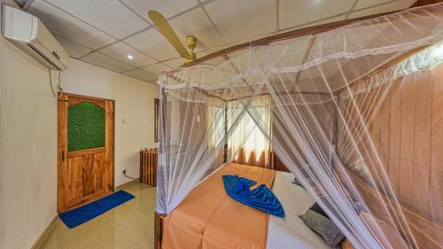 a bedroom with a bed with a mosquito net at Sky Garden Mini Hotel in Mirissa