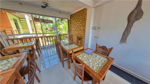 a dining room with tables and chairs and a window at Sky Garden Mini Hotel in Mirissa
