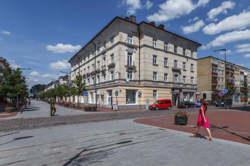 a woman walking down a street in front of a building at Avenue in Šiauliai