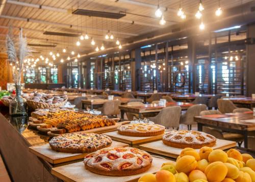 a buffet with many different types of cakes and pies at Ambassadori Kachreti Golf Resort in Kachretʼi