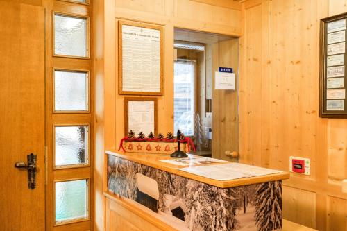 a kitchen with a counter in a room with wooden walls at Apartments Antares in Colfosco