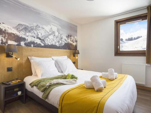 a bedroom with a large bed with towels on it at Résidence Les Chalets des Cimes 5 in Hauteluce