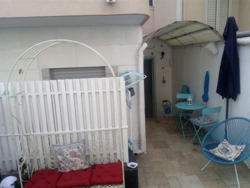 a room with a crib and a table and chairs at Blue sea in Aci Castello