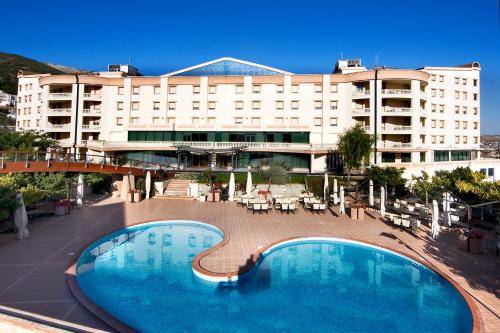 a hotel with a large swimming pool in front of a building at Gran Paradiso Hotel Spa in San Giovanni Rotondo