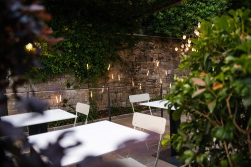 a group of tables and chairs in a garden with lights at Le Funi Hotel in Bergamo