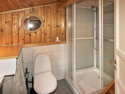 a bathroom with a shower with a toilet and a chair at Holiday Home Krolia in Tjaldal