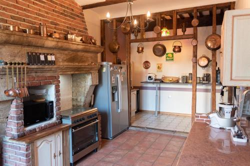 a kitchen with a refrigerator and a stove in it at La Fée Maison in Châtel-sur-Moselle