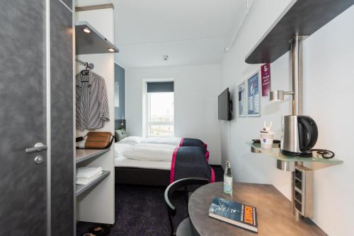 a small room with a bed and a table at Cabinn Copenhagen in Copenhagen
