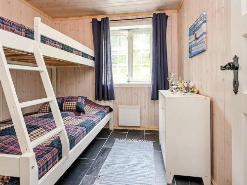 a bedroom with two bunk beds and a refrigerator at 11 person holiday home in F vang in Favang