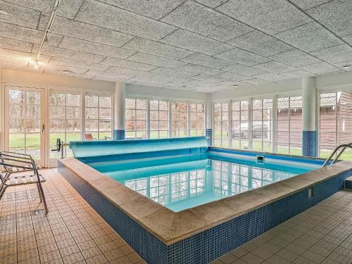 een groot zwembad in een gebouw met een zwembad bij Holiday Home Brinken in Frederiksværk